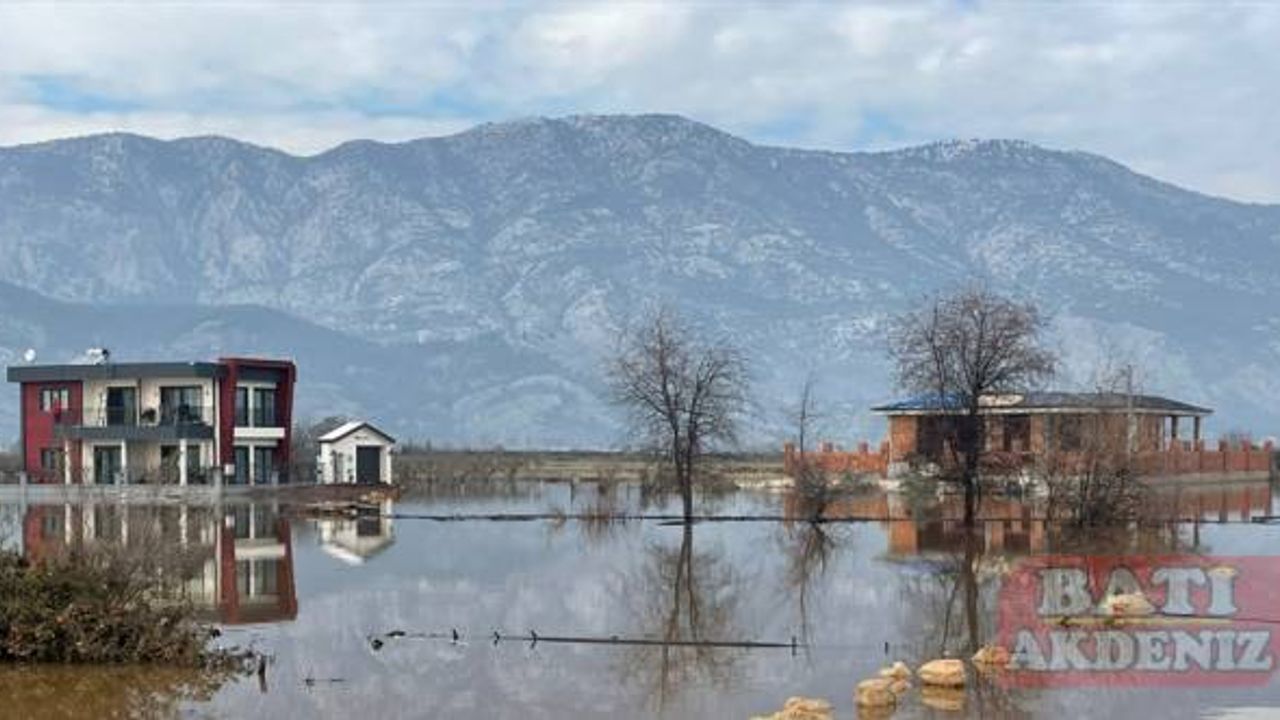 Antalya'da yağmur suları nedeniyle evlerinden çıkamayanlar iş makinasıyla taşınıyor